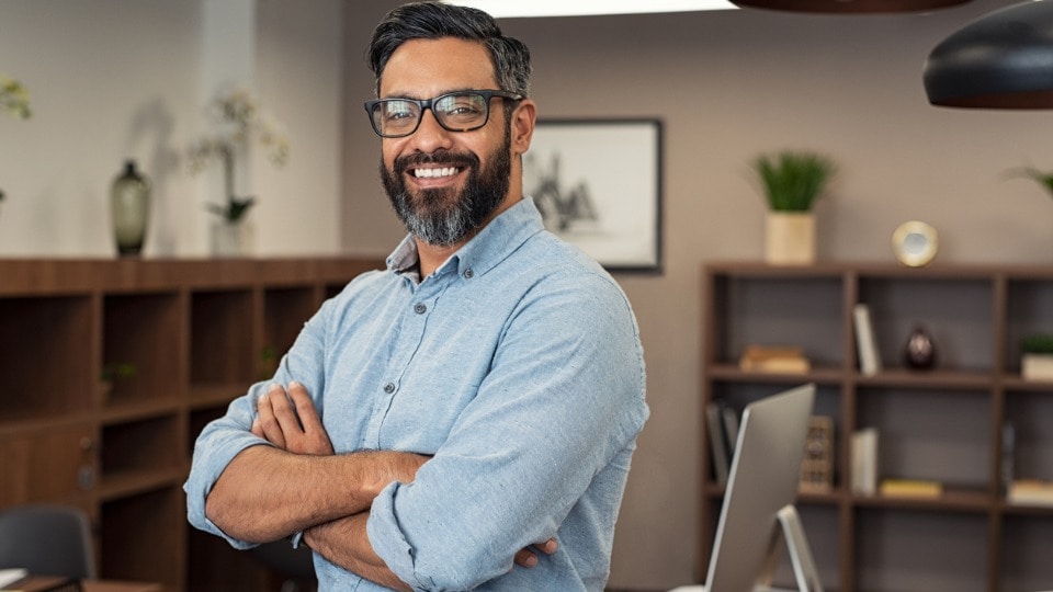 Portrait of happy mature businessman wearing spectacles and looking at camera